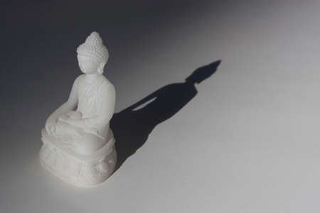 White Buddha statue, cast a shadowの写真素材