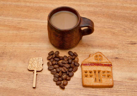 A cup of coffee with biscuit and and coffee beans, laid out in the form of heartの写真素材