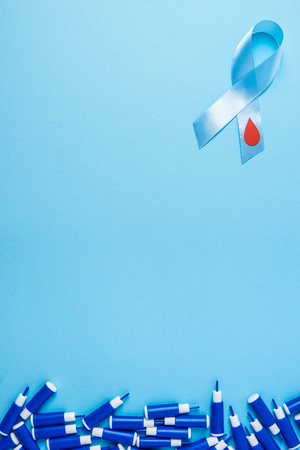 blue ribbon awareness with red blood drop and line of lancets on a blue background. World diabetes day,14 november. Copy space. Top viewの写真素材