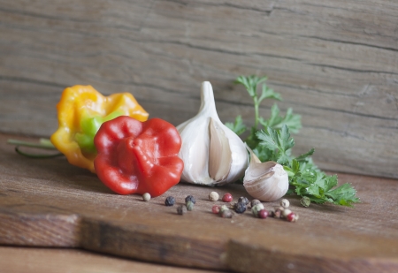 fresh pepper, garlic and parsley on a wooden boardの写真素材