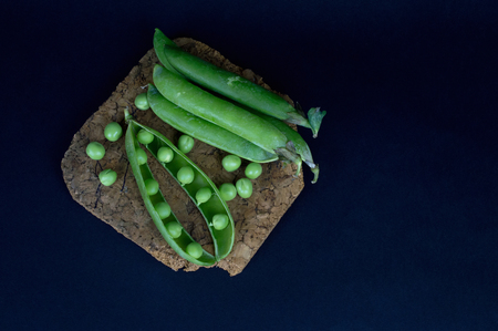 Fresh green peas and peas lie on black background. Top viewの写真素材