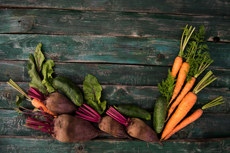 fresh farm vegetables beetroot, carrots and cucumbers on a woodeの写真素材