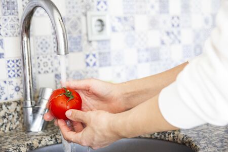 Tomatoes, cucumbers, cabbage in washing processの写真素材