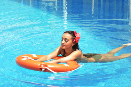 Beautiful woman tanning in a swimming poolの写真素材