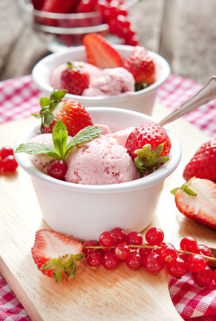 Homemade strawberry ice cream decorated with fresh berries and mintの写真素材