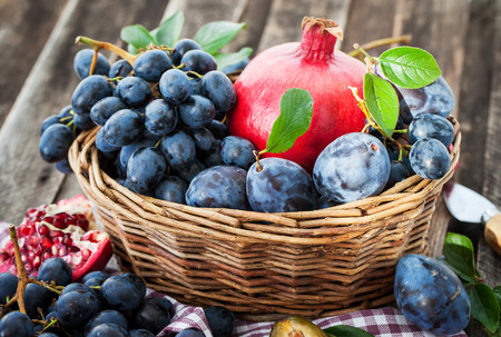 Fresh autumn fruits - pomegranate, plums, grapes and applesの写真素材