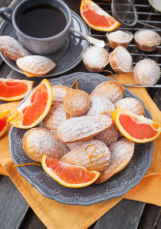 Fresh homemade orange madeleines cookies and coffeeの写真素材