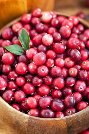 Fresh red cranberry in wooden bowl on the tableの写真素材