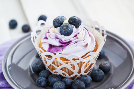 Tasty blueberry cupcake decorated with cream and fresh berriesの写真素材