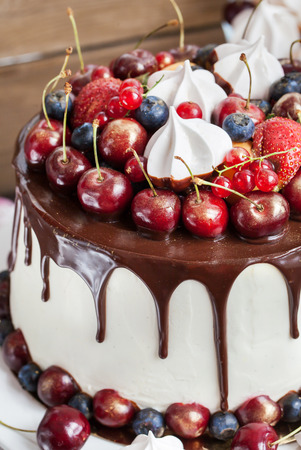 Delicious homemade cake decorated with chocolate, meringues and fresh berriesの写真素材