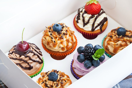 Set of different delicious cupcakes in a paper boxの写真素材