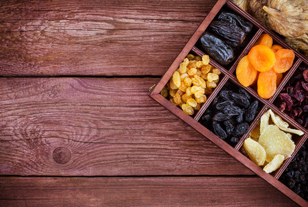 ?ssorted dried fruits in wooden printers box-figs, raisins, date, cranberries, currant, pears, ginger and apricots. Top view.の写真素材