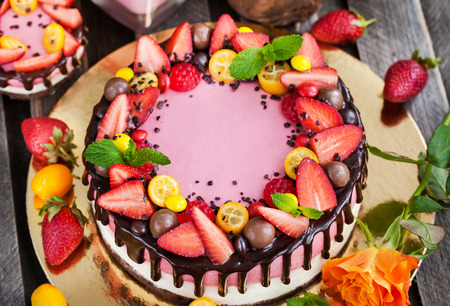 Delicious two-ply strawberry cheesecake (cake) decorated with chocolate and fresh berriesの写真素材