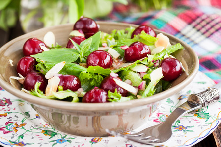 Summer green salad with fresh cherry, almond and vinaigrette dressingの写真素材