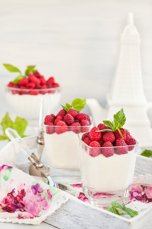 Delicious sweet creamy mousse  in a glass decorated with fresh raspberriesの写真素材
