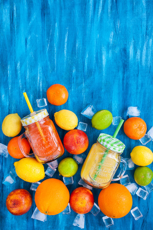 Citrus vitamin juice in mason jars with fresh oranges, mandarins, lemons and limes around, healthy drinkの写真素材