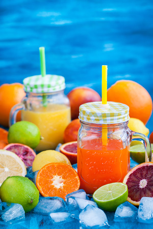 Citrus vitamin juice in mason jars with fresh oranges, mandarins, lemons and limes around, healthy drinkの写真素材