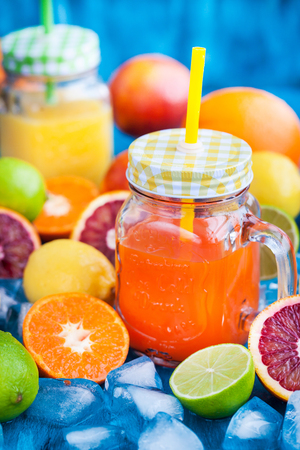 Citrus vitamin juice in mason jars with fresh oranges, mandarins, lemons and limes around, healthy drinkの写真素材