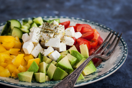 Fresh delicious tomato, bell pepper, cucumber, avocado, onion and feta saladの写真素材