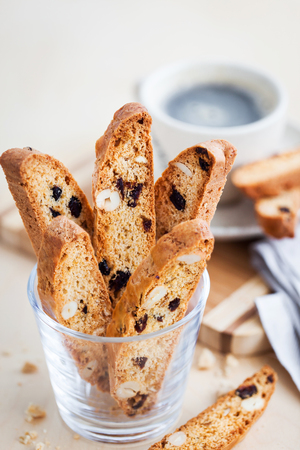 Italian cranberry almond biscotti  and cup of coffee on backgroundの写真素材