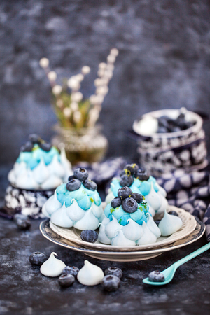 Delicious blueberry Pavlova meringue cakes decorated with cream and fresh berriesの写真素材
