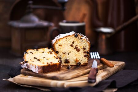 Delicious homemade cottage cheese and raisins loaf cake on dark rustic wooden background
