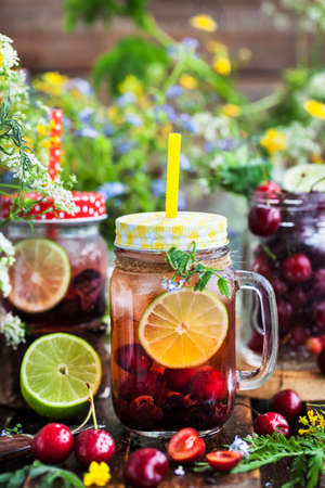 Healthy homemade cold lemonade with fresh berries and fruits in mason jar