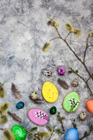 Delicious Easter cookies and painted eggs on gray background, top view
