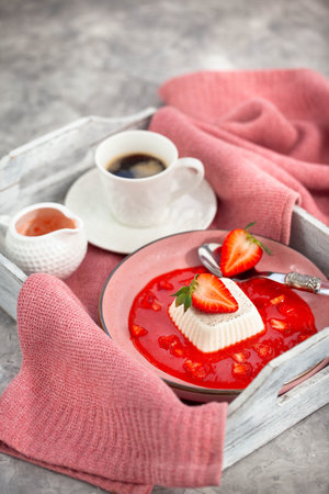 Delicious Italian dessert Panna Cotta with strawberry sauce and fresh berriesの写真素材