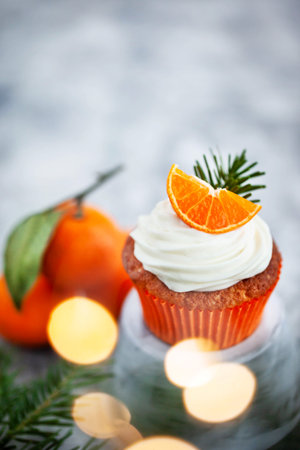 Homemade delicious tangerine and carrot cupcakes, decorated with creamcheese and fresh citrus fruitsの写真素材