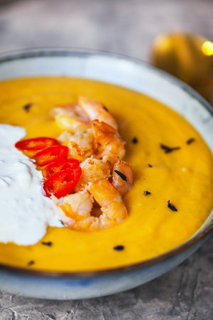 Delicious fresh cooking hot pumpkin and sweet potato soup, served with prawns, chili and stracciatella cheeseの写真素材