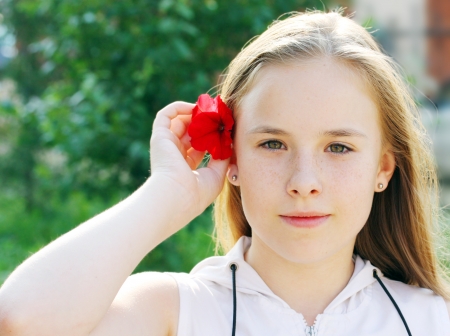 Closeup of pretty young girl with flower in her hairの写真素材