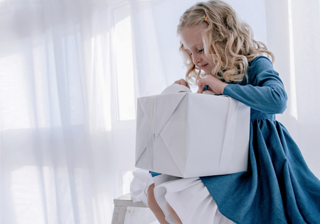 the girl opens the gift box on a white backgroundの写真素材