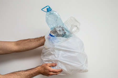 Man hand holding garbage with plastic bottles
