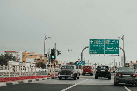 Dubai Jumeirah road car traffic with many cars, direction road boards, traffic lights and sightseeing objectsの写真素材