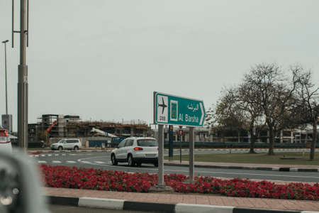 Dubai Jumeirah road car traffic with direction road boards, traffic lights and sightseeing objectsの写真素材