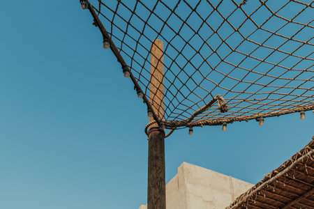 Decorative rope netting and string lights outdoor with blue sky on the backgroundの写真素材