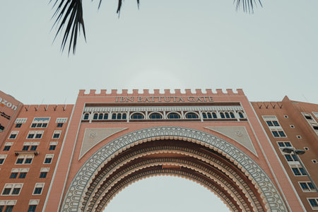 Dubai, UAE - October 6, 2020: Oaks Ibn Battuta Gate hotel building architecture closeup with blue sky and palm treeのeditorial素材