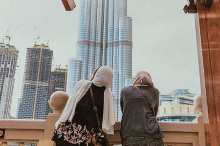 Two women in hijabs enjoy Burj Khalifa view from Souk Al Baharの写真素材
