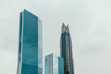 Modern skyscrapers with unique architectural designs against a cloudy sky