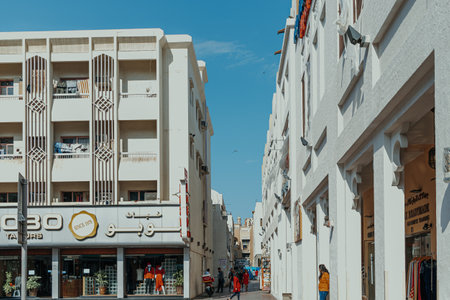 Dubai, UAE - January 6, 2020: Narrow street in Bur Dubai with local shops and residential buildings under bright blue skyのeditorial素材
