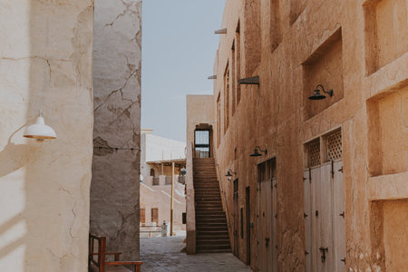 Narrow historic alley with stone buildings and stairs in Al Seef Old Dubai districtの写真素材