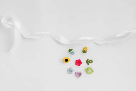 Sewing accessories on a white background. Sewing threads, pins, fabric, buttons. Top view, flat lay. Spring colorの写真素材