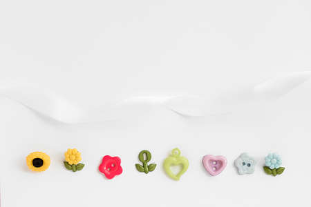 Sewing accessories on a white background. Sewing threads, pins, fabric, buttons. Top view, flat lay. Spring colorの写真素材