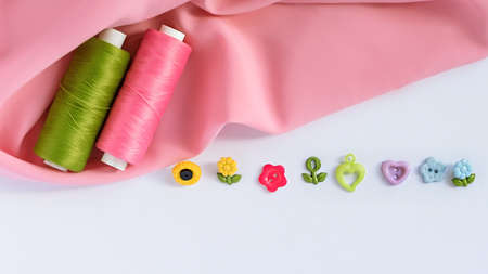 Sewing accessories and fabric on a white background. Sewing threads, pins, fabric, buttons. Top view, flat lay. Spring colorの写真素材