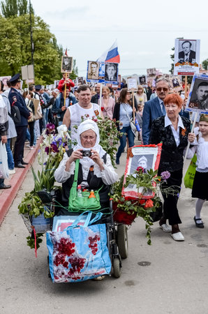 Kerch, Russia 05 09 2019: Parade Victory Day. People participate in the patriotic action Immortal Regiment. They are holding portraits of people who participated in the Great Patriotic War.のeditorial素材