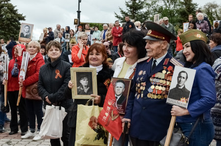 Kerch, Russia 05 09 2019: Parade Victory Day. People participate in the patriotic action Immortal Regiment. They are holding portraits of people who participated in the Great Patriotic War.のeditorial素材