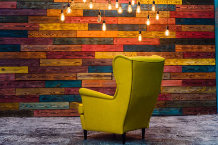 beautiful lounge room, yellow armchair, lamps and decorated wall, studio interior.の写真素材