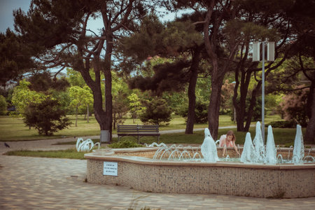 A green lawn in the park summer day. fountain in the park. Summer landscape.のeditorial素材
