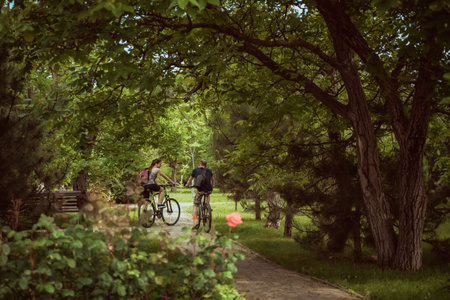 people ride bicycles in the park summer day. Summer landscape.のeditorial素材